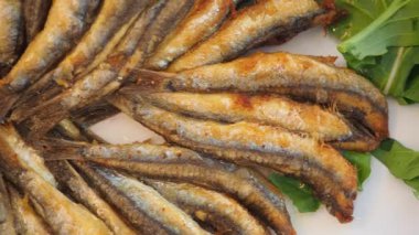 Taze yeşilliklerle hazırlanmış kızarmış balığın tadını çıkarın..