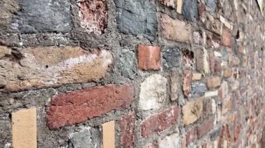 İlginç renklere ve dokulara sahip bir tuğla duvarın yakın görüntüsü.