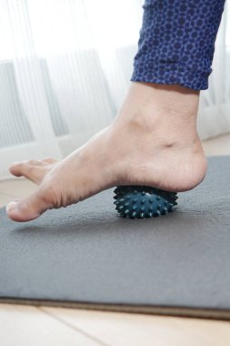 Bir insan evdeki paspasın altına dikenli bir top yuvarlıyor..