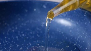 Yağ, yemek hazırlığı için mavi bir kaseye sürekli olarak dökülür..