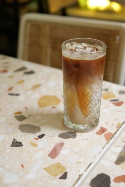 Katmanlı soğuk bir içecek renkli bir masada oturur..