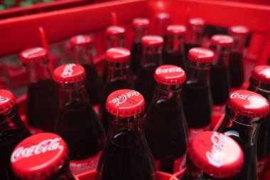 Serinletici gazoz şişeleri markette kırmızı bir sandıkta paketlenir..