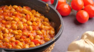 Lezzetli bir domates sosunda taze sarımsaklı nohut pişirmeyi öğren..