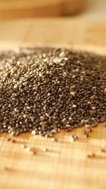 Chia tohumları ahşap bir kesme tahtasına saçılmış, dokularını sergiliyorlar..