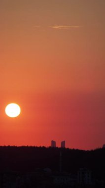 Gün batımının tadını çıkar. Güneş şehrin arkasında batıyor..