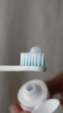 Yakın plan çekimde mavi diş fırçası ve diş macunu kullanıma hazır..