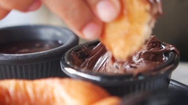 Sıcak bir kafede kruvasanlar zengin çikolatalara batırılır..