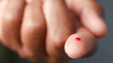 Şeker hastalığını ölçmek için parmak ucunda duran kan damlasına yakından bakın. 