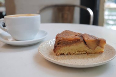 Sıcak bir ortamda bir fincan kahveyle bir dilim pastanın tadını çıkar..