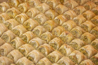 Tatlı baklava katmanları büyük bir tepside düzgünce dizilmiştir..