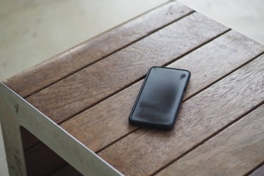Cep telefonu ahşap masada dinleniyor. Akıllı telefon kavramını kaybettim.