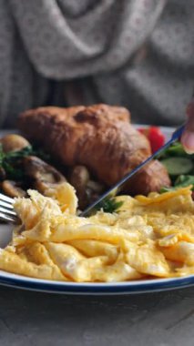 Bir insan içinde yumurta, tavuk ve sebzeler olan doyurucu bir tabağın tadını çıkarır..