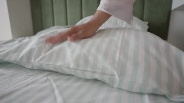 Bir insan temiz bir yatak ve yastık hazırlar..