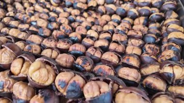 Tedarikçiler sonbaharda markette taze kavrulmuş kestane sergiliyorlar..