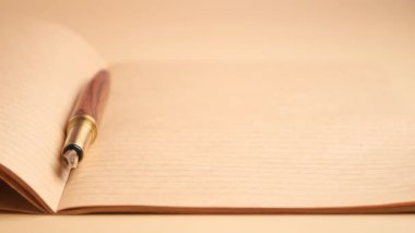 Tahta bir masanın üzerine bir deftere düşünceler yazıyor..