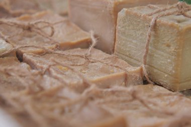 Yerel bir markette sicimle düzgünce bağlanmış çeşitli el yapımı sabunlar..