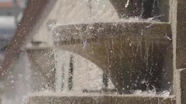 Su yavaşça taşın üzerine dökülür ve dışarıda barışçıl bir atmosfer yaratır..