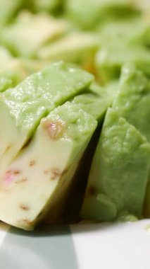 Parlak yeşil avokado dilimleri sağlıklı bir yemek seçeneği olarak hazır..