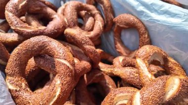 Müşteriler bir pazarı keşfederler ve bir satıcıdan gelen sıcak simit ile eğlenirler..