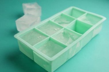 Tepside buz küpleri var, deniz mavisi zemininde. Bazı küpler çıkarılır..