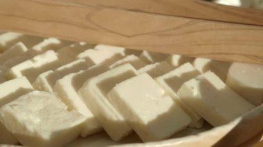 Taze peynir parçaları yerel bir markette ahşap bir tepside düzenlenir..