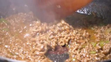 Baharat ve baharatlarla dolu bir tavada tuzlu et kaynıyor..