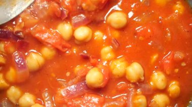 Olgun domates ve baharatlarla yapılan sıcak ve rahatlatıcı nohut yahnisinin tadını çıkarın..