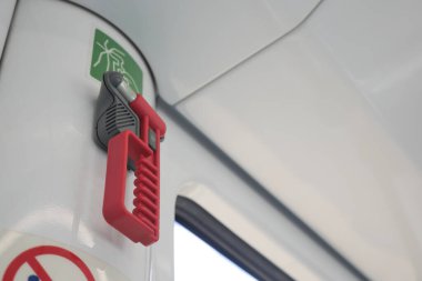 Kırmızı acil durum kolu bir nakliye aracının duvarına monte edilmiş..