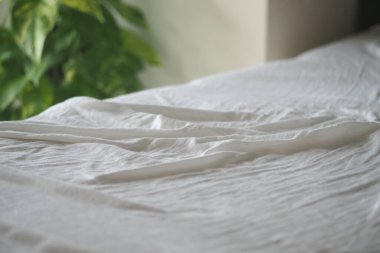 Işık, pürüzsüz beyaz yatağa düşer, sakin ve taze bir atmosfer yaratır..