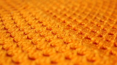 Turuncu kumaşın desenlerine ve dokusuna ayrıntılı olarak bak..