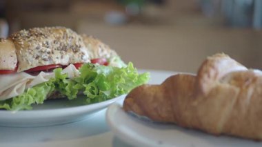 Sıcak bir kafede servis edilen lezzetli sandviçler ve kruvasanlar..