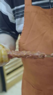 Şef usta bir şekilde markette ızgara et şişleri hazırlar..