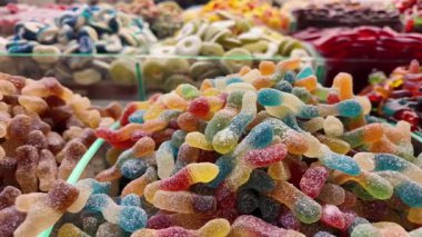 Parlak renkli jelibonlar bir şeker dükkanında müşterileri cezbeder..