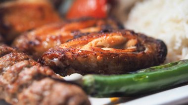 Canlı bir ızgara et tabağında tavuk, sebze ve pirinç yer alır..