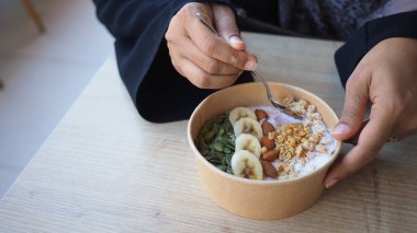 Sabahları muzlu, fındıklı ve tahıllı yoğurt kasesinin tadını çıkarıyorum..