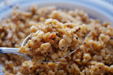 Bir kaşık dolusu lezzetli pişmiş tahıl birçok kişi tarafından tadını çıkarmaya hazır..