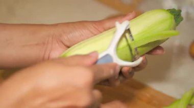 Bir insan rahat bir mutfakta kabak soymakta ustalaşır..