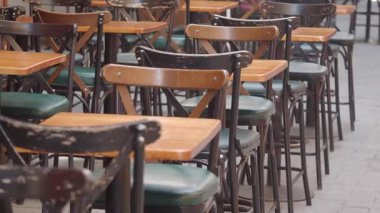 Tahta masalar ve sandalyeler bir kafede düzenli olarak müşterileri bekliyor..