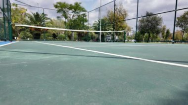 Oyuncular tenis yeteneklerini dışarıda sıcak bir öğleden sonra çalışırlar..