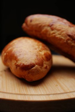 Taze pişmiş ekmek ruloları ahşap bir yüzeyde dinleniyor..