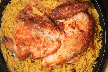 Kızarmış tavuk, baharatlı pirinç yatağında dinleniyor, yemeye hazır..