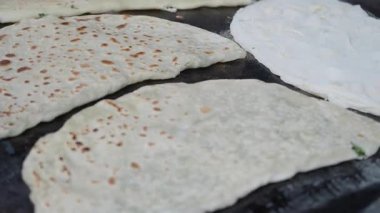 Uzman tekniğiyle sıcak bir ızgarada pişen düz ekmekleri izleyin..