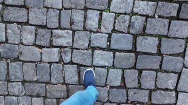 Cazibeyle çevrili bir kaldırım taşı caddesinde yürüyen biri..