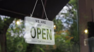 Açık bir hoş geldin tabelası insanları sıcak bir kahve dükkanına davet eder..