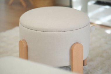 Yumuşak kumaşlı yuvarlak bir şilte rahat bir yaşam alanında oturur..