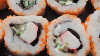 Yengeç ve sebzelerle dolu taze suşi ruloları servis edilir..