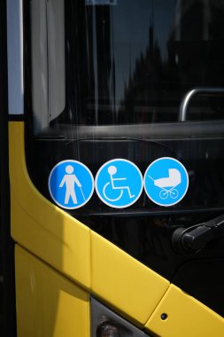 Toplu taşıma araçları kullanan kişiler için erişilebilirlik seçeneklerini gösteren işaretler.