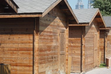 Ahşap kulübeler düzgünce düzenlenir, doğal dokuları ve renkleri sergilenir..