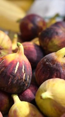 Bir pazarda sergilenen renkli incirler, sıcak güneş ışığında alıcıları cezbediyor..