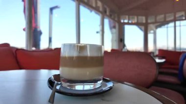 Rahatlatıcı bir an, manzaralı bir kafede katmanlı kahvenin tadını çıkarıyorum..